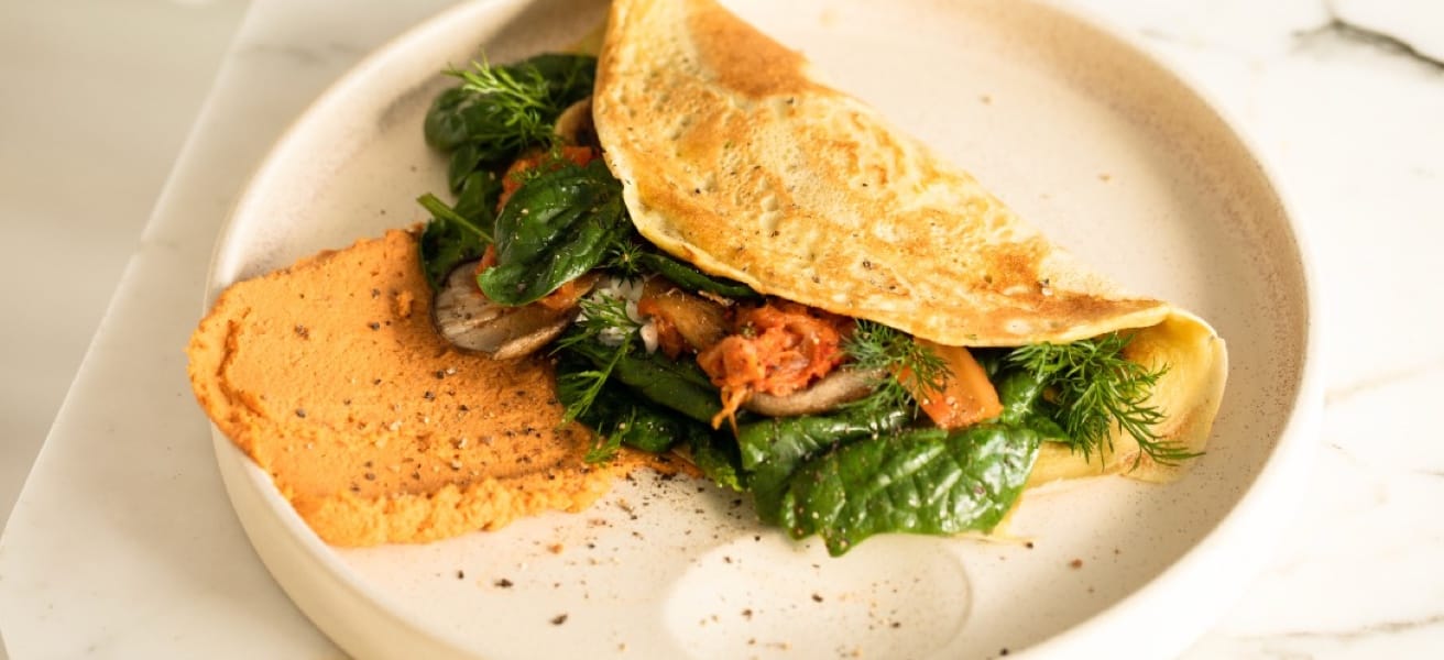 Omelette served on a plate with greens